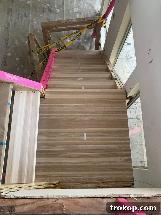 Close-up of the thick ash wood stair treads, highlighting their natural texture and robust construction, ready for the final railing installation.