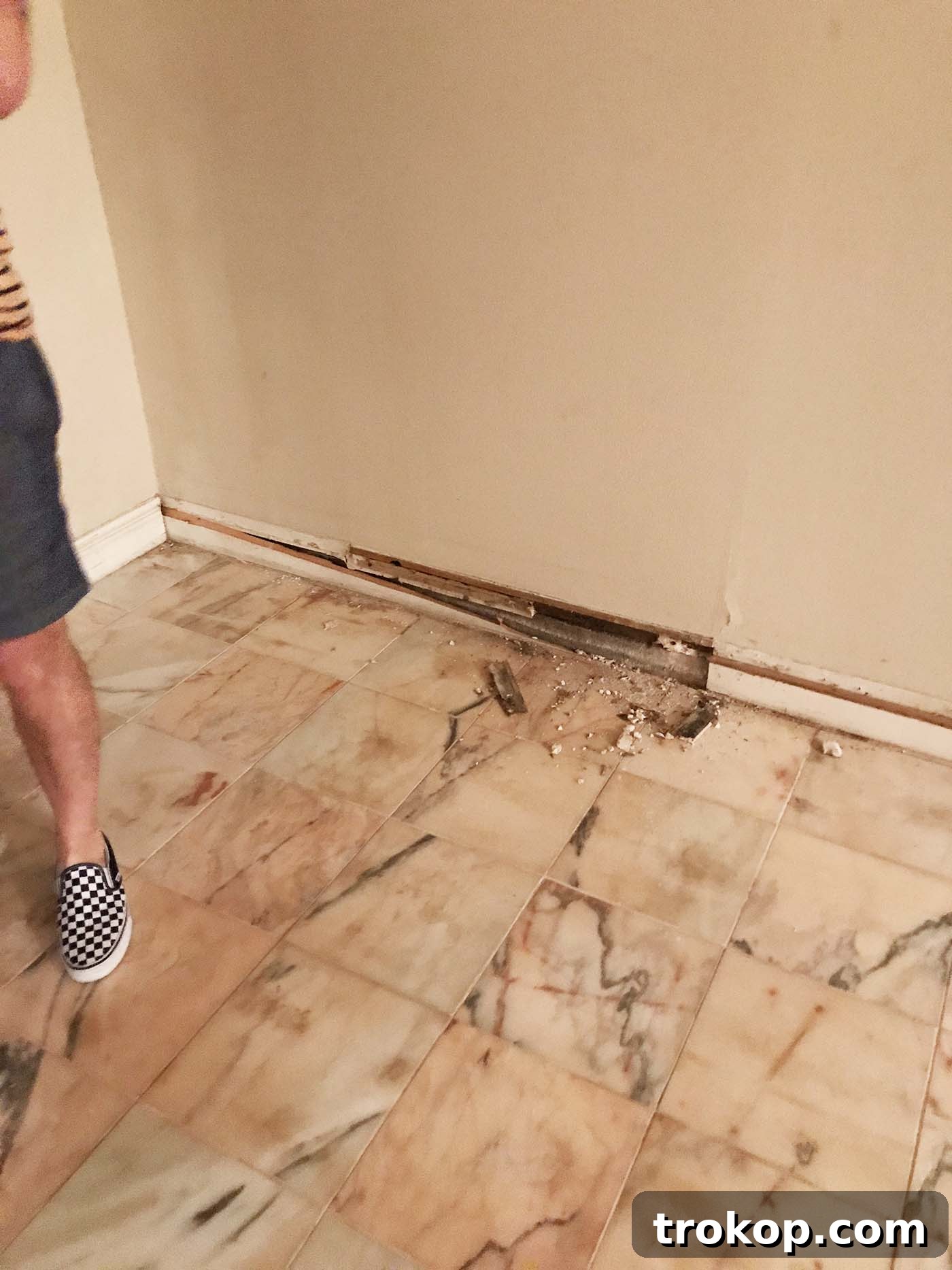 Construction crew working on exposed foundation and addressing severe water ingress issues during a major living room renovation in Houston