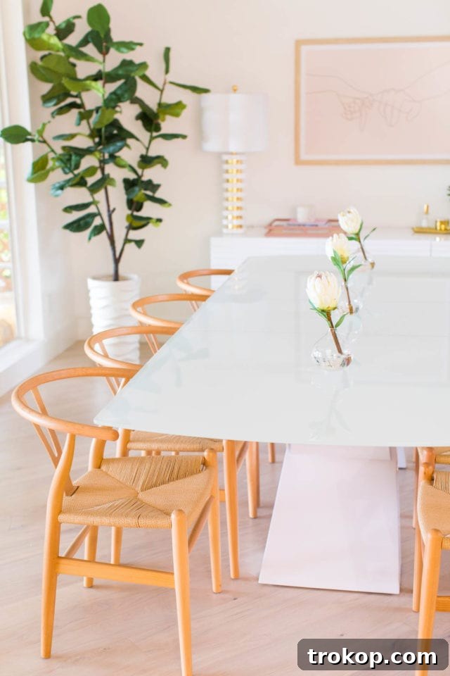 Elegant dining space with an extendable white dining table, Tia Y chairs, and a striking Hudson Valley Lighting chandelier, perfect for entertaining.