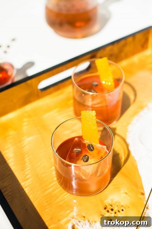 A styled photo of a Coffee Old Fashioned cocktail on a dark background.