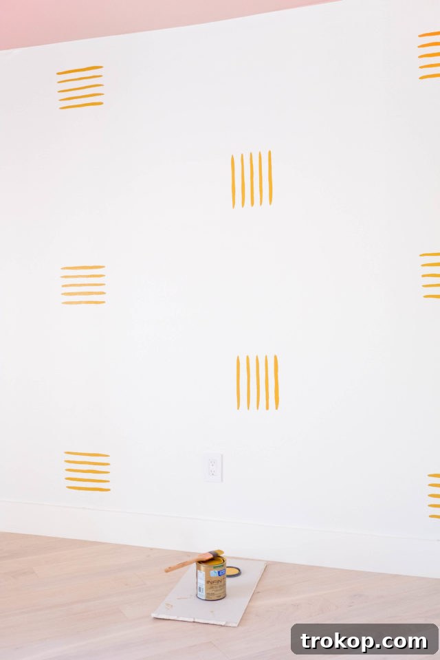 Painting the hand-drawn accent wall lines with an angled brush.