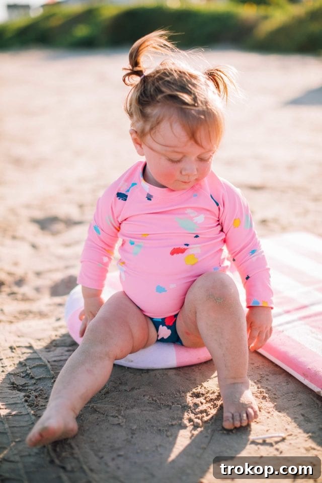 Ashley Rose of Sugar & Cloth smiling in the striped mom bod one-piece, showcasing the comfortable and stylish fit of her Olivia + Ocean collaboration swimwear.