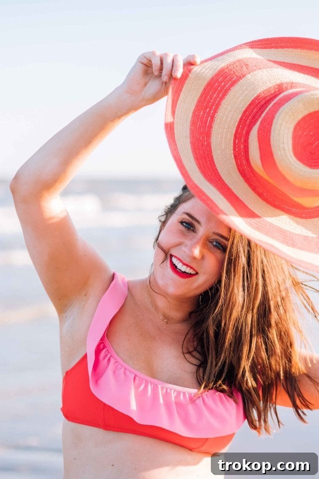 Gwen, Ashley Rose's daughter, in the high-waisted coral red and perfect pink color block bikini, smiling confidently and showing off the playful design.