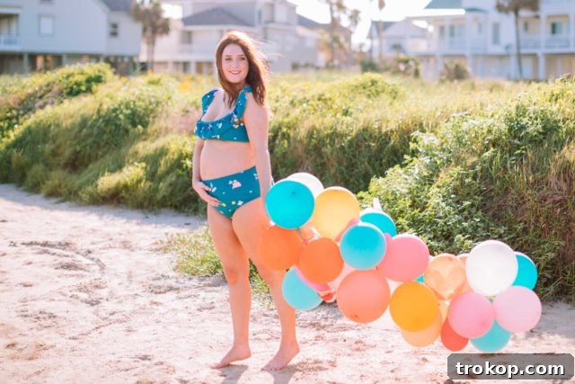 Ashley Rose of Sugar & Cloth with her daughter Gwen, both in matching confetti print swimwear, enjoying a playful moment. Ashley is in a bikini, Gwen in a one-piece.