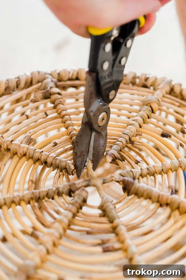 Woven Basket Pendant Light 7 Using heavy-duty cutting pliers to create a hole in the bottom center of a woven basket.