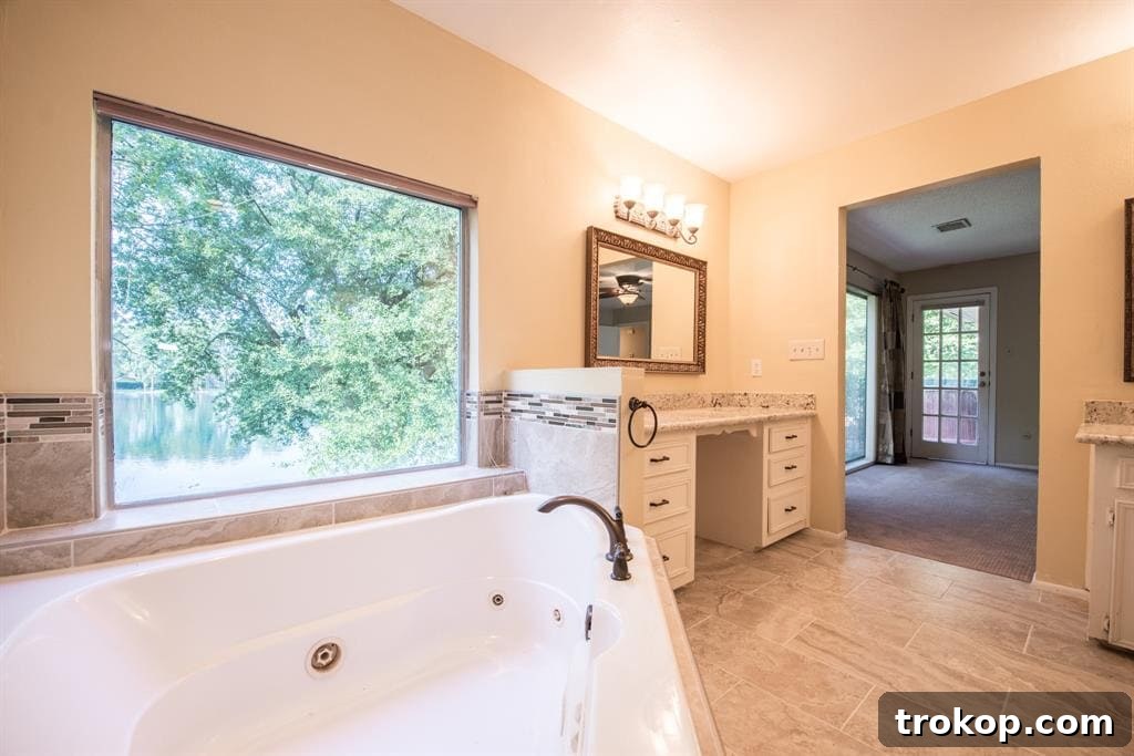Before photo of an outdated master bathroom vanity with old wooden cabinetry, worn countertop, and traditional sink, destined for a sleek, modern renovation by Sugar & Cloth.