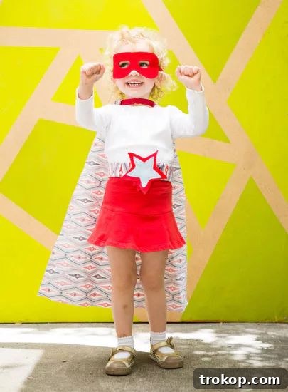 Girl in a custom DIY Superhero Halloween costume with cape and mask