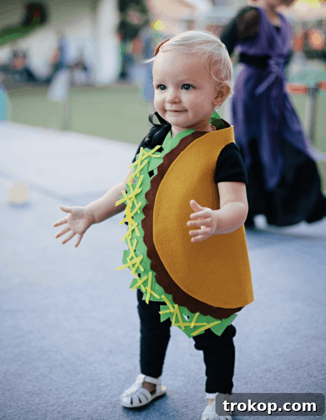 Cute toddler in a no-sew felt taco Halloween costume with colorful fillings
