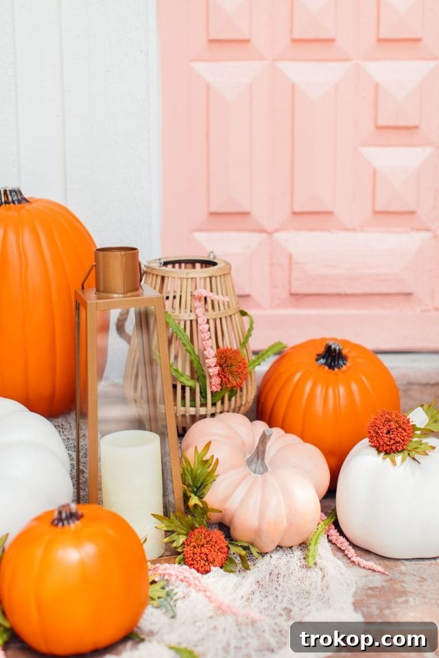Whimsical Halloween Door Decorating Ideas 14 A charming display of pumpkins in varying colors and sizes in front of a pretty pink door, part of Halloween decor