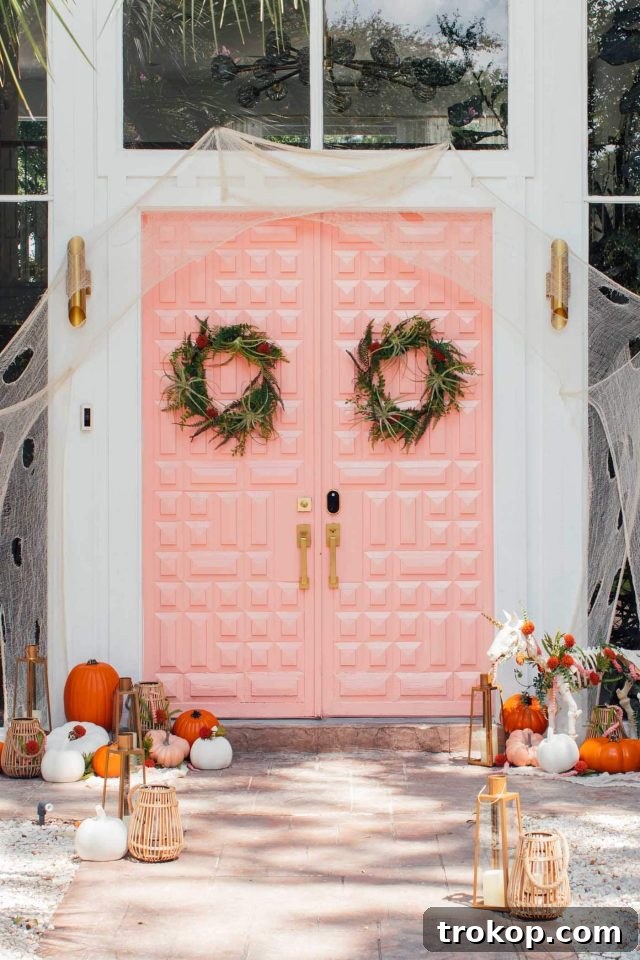 Whimsical Halloween Door Decorating Ideas 15 An inviting pink front door showcasing elegant Halloween door decor with a subtle spooky charm