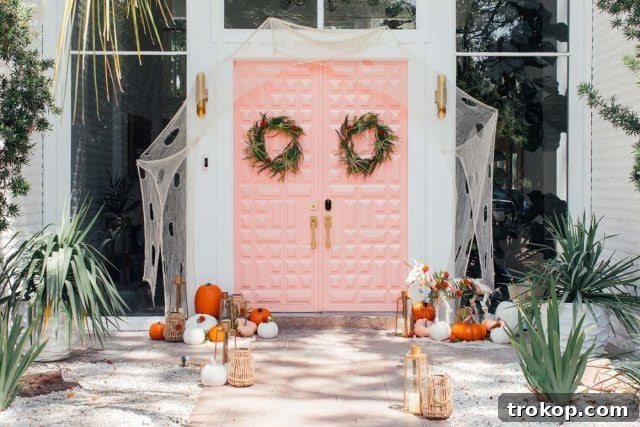 Whimsical Halloween Door Decorating Ideas 5 A vibrant pink front door adorned with stylish and not-so-spooky Halloween decorations