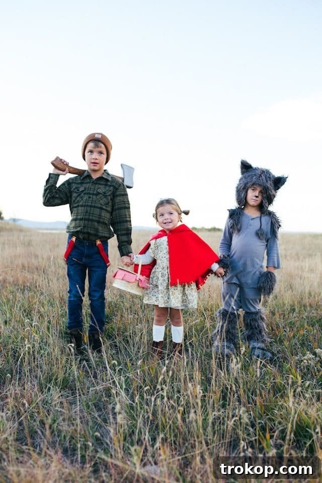 40 Spooktacular Family Halloween Costume Ideas 22 Three siblings dressed in enchanting Little Red Riding Hood inspired Halloween costumes, featuring different characters from the tale.