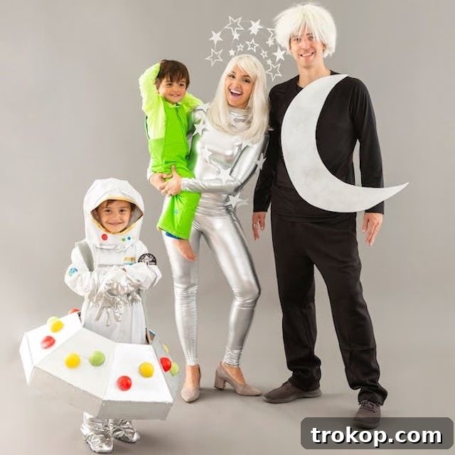 40 Spooktacular Family Halloween Costume Ideas 23 A family of four dressed in a whimsical outer space themed Halloween costume, featuring a moon, stars, UFO, and an alien.