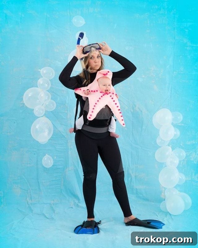 40 Spooktacular Family Halloween Costume Ideas 31 A mother dressed in scuba gear carrying her baby dressed in a cute starfish costume in a baby carrier.