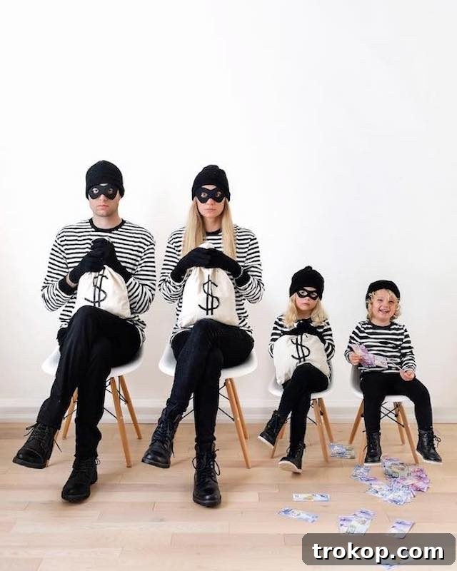 40 Spooktacular Family Halloween Costume Ideas 5 A family dressed in matching black and white striped bank robber Halloween costumes, complete with masks and money bags.