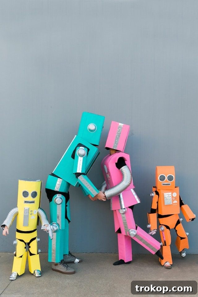 40 Spooktacular Family Halloween Costume Ideas 8 A family creatively dressed in DIY robot Halloween costumes made from cardboard boxes and colorful accents.