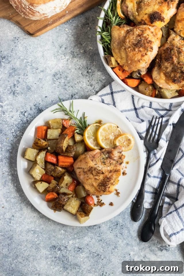 Easy One Pan Lemon Rosemary Chicken 3 Close-up photo of a healthy and satisfying lemon rosemary chicken dinner on a white plate