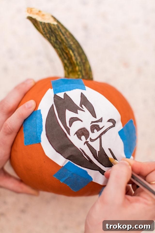 Tracing a stencil on a pumpkin