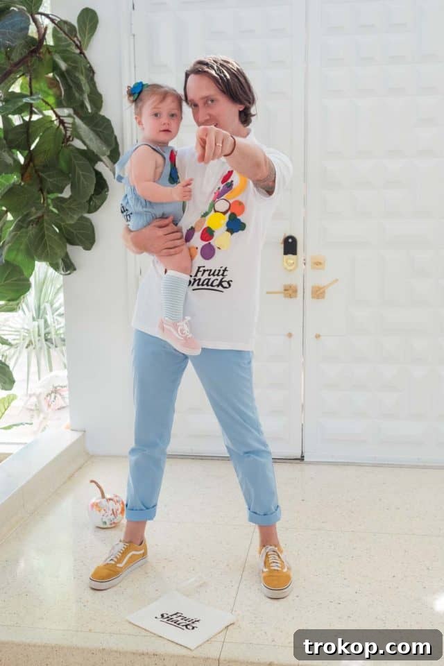 Father and daughter striking a pose in their adorable and easy-to-make fruit snacks themed Halloween costumes.