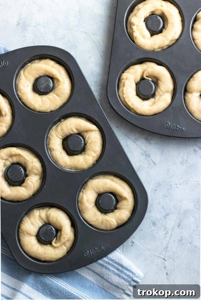 Gluten-free donuts batter beautifully prepared in donut pans, ready for baking to achieve a perfect golden finish, by top Houston lifestyle blogger Ashley Rose of Sugar & Cloth.