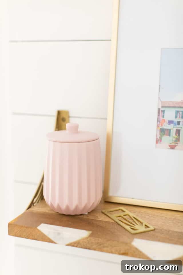 Decorated wet bar with scalloped napkins, a light wood vase, and pink accessories