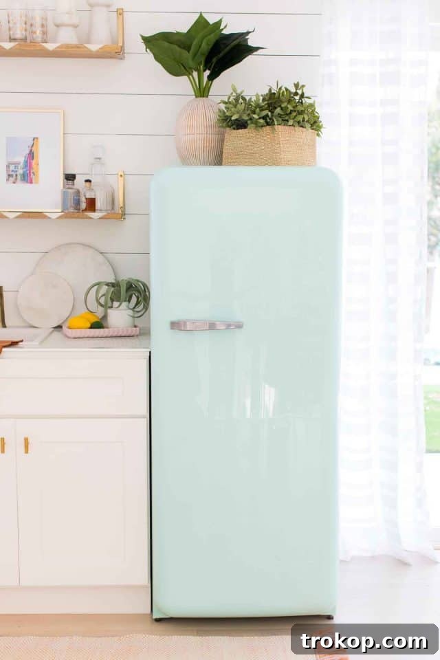 Close up of the mint green Smeg fridge in the game room wet bar