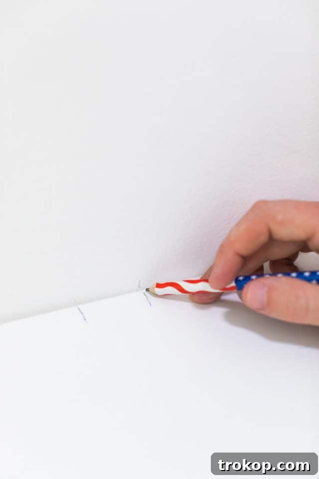 Preparatory steps for mounting IKEA Eket cabinets: measuring and marking the wall for precise placement.