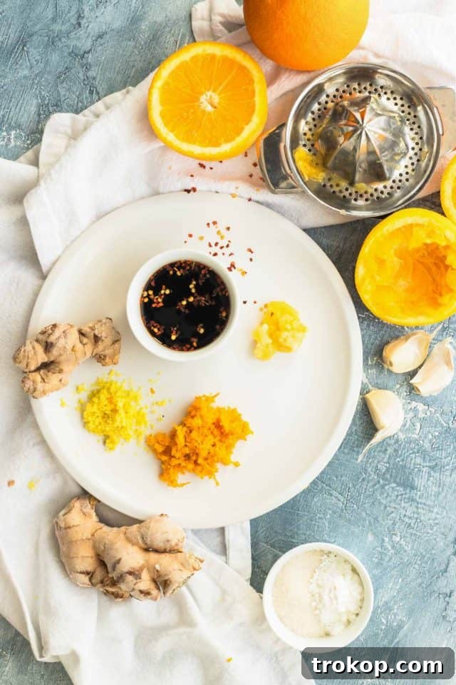 Zesty Orange Chicken 3 Ingredients laid out for an easy orange chicken recipe, showcasing fresh produce and pantry staples, by Houston lifestyle blogger Ashley Rose of Sugar & Cloth.
