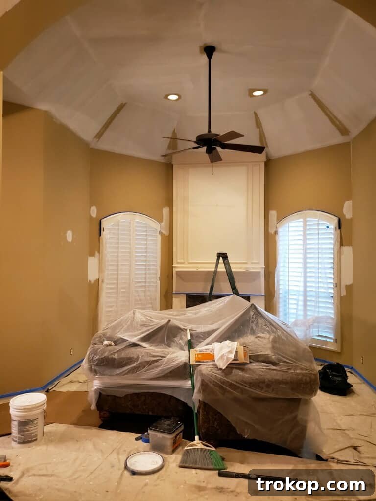 A Transitional Living Room's Stunning Style Transformation 4 Photo of the living room walls being painted with a light, neutral color to brighten the space during the transitional makeover.