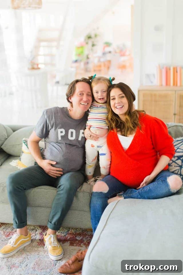 photo of my husband wearing a fake pregnant belly with our family, smiling and looking at the camera