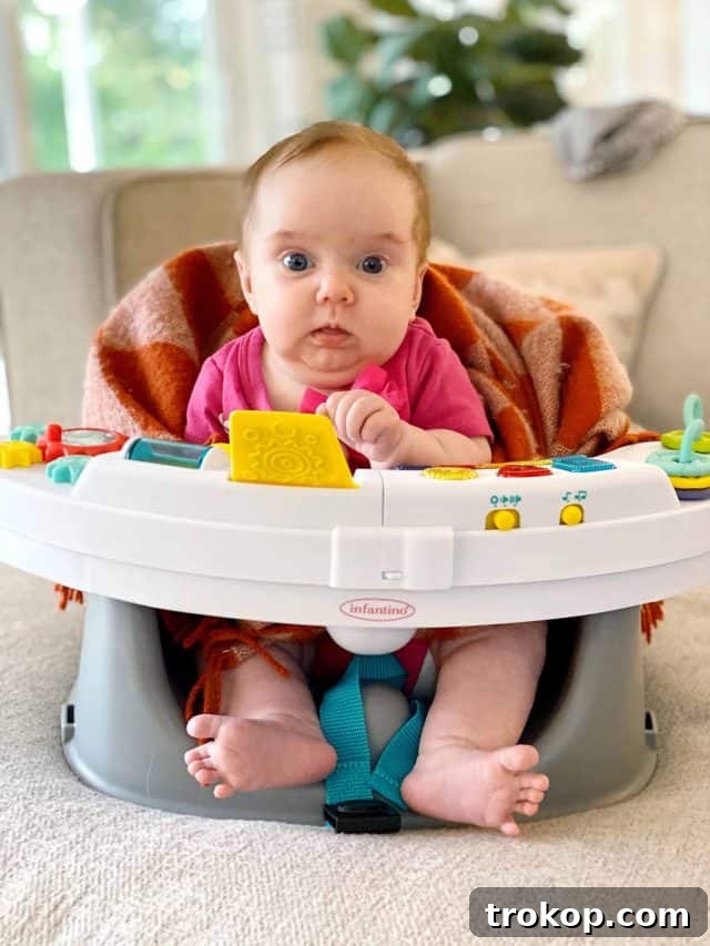 The Weekly Edit Homeschool Highlights and Your Watchlist 2 A baby in a play chair, smiling, suggesting a moment of peace amidst family life.