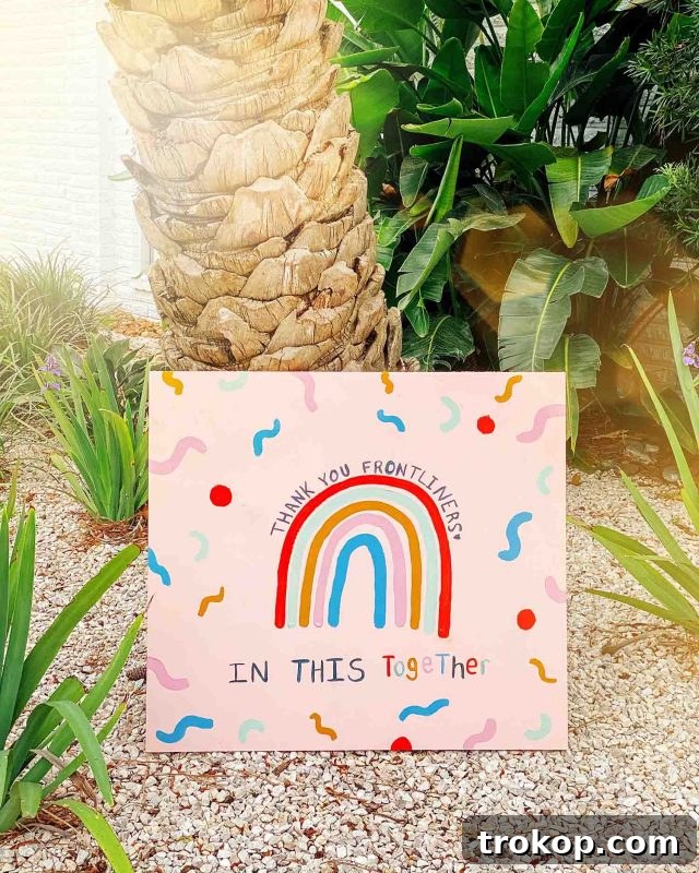 Woman painting a 'thank you' sign with colorful letters