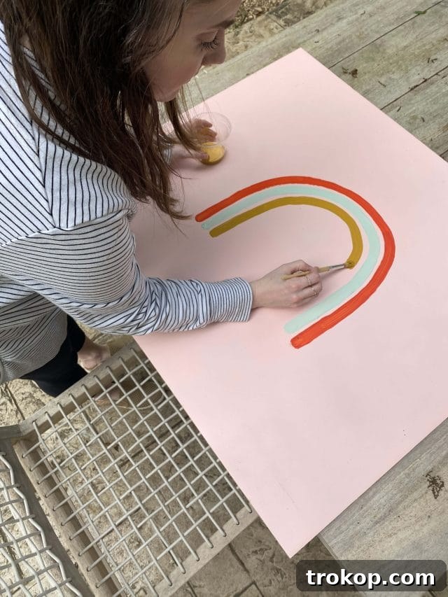 Close-up of hands painting a rainbow design