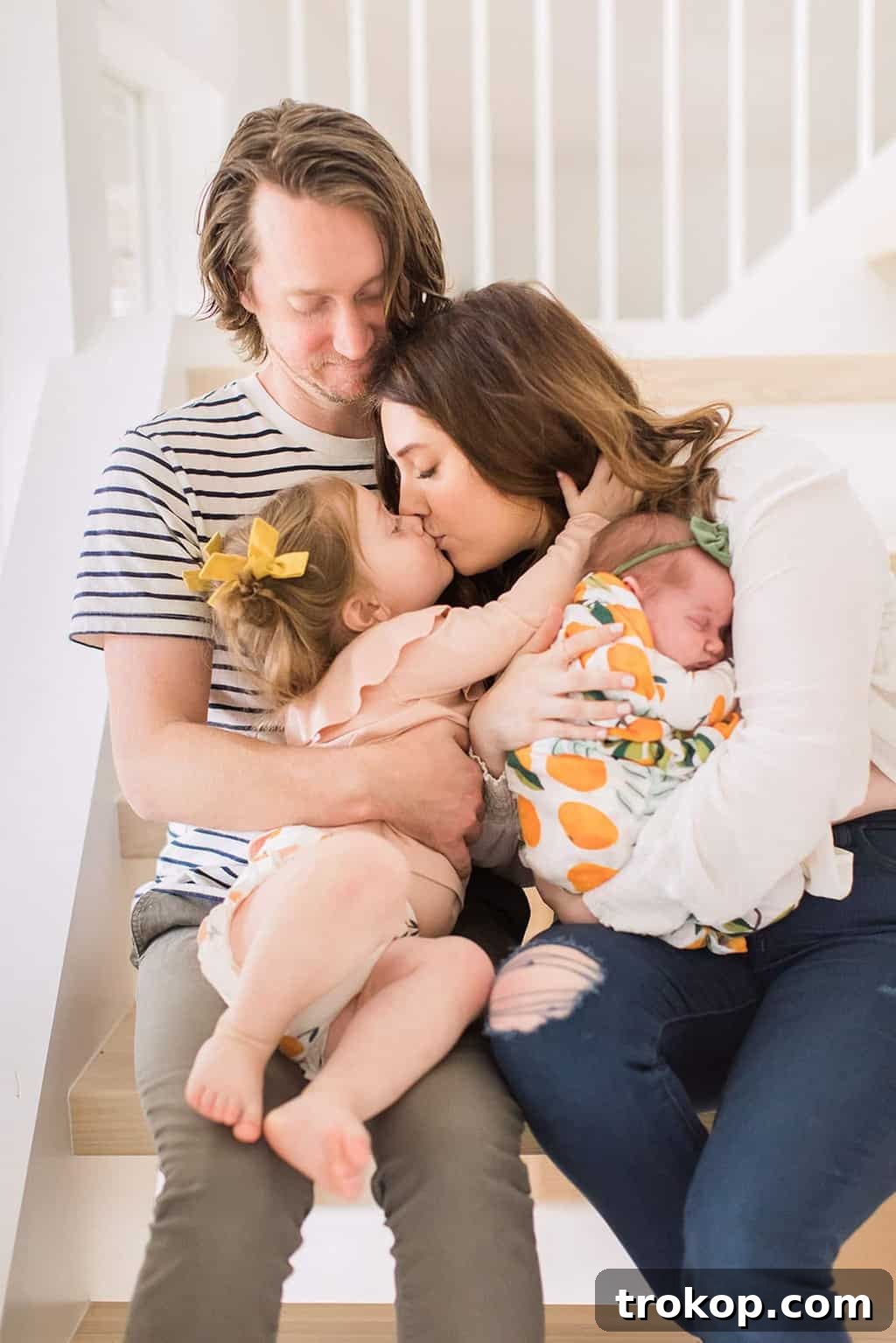 Luca's Newborn Journey: Our Favorite Captures 2 Warm family newborn photo on stairs, featuring parents, toddler Gwen, and baby Luca