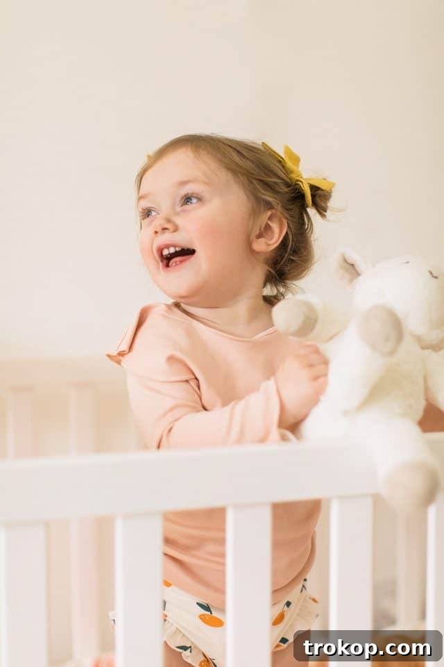 Luca's Newborn Journey: Our Favorite Captures 6 Toddler Gwen sitting thoughtfully in her stylish house-shaped crib