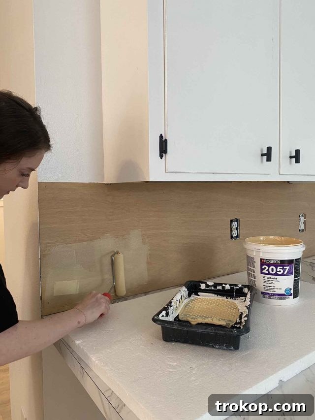 Weekly Highlights: Garage Makeover and Home Finds 4 Close-up of a kitchen backsplash being installed with peel and stick tiles, showing the DIY process.