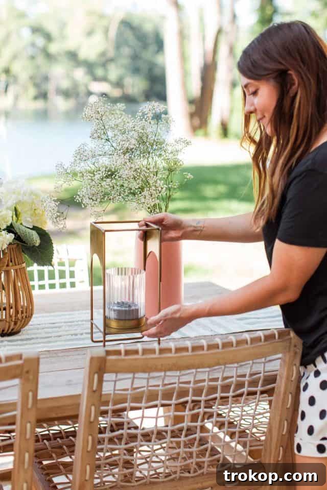 A girl placing a decorative brass lantern on an outdoor dining table, preparing for a fly-free meal.