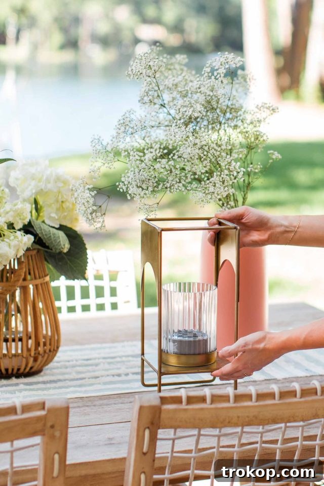 A decorative brass lantern being carefully placed on an outdoor table, adding a stylish touch while serving as a fly repellent.