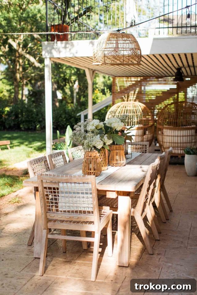 A serene photo of an Article Teaka outdoor dining table and chairs set in a natural outdoor environment, showcasing an ideal dining space.