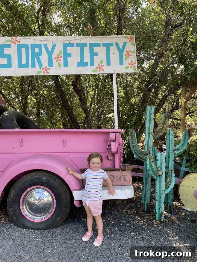 Gwen in front of a vibrant pink vintage truck at Garner State Park