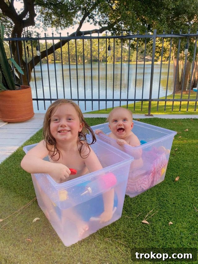 The Weekly Home Edit 3 Gwen and Luca sharing a joyful outdoor bath on the deck, creating precious sibling memories under the open sky.