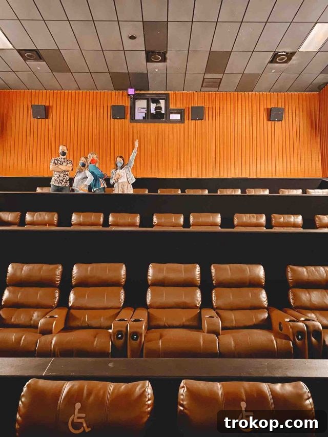 A group of friends or family members posing cheerfully outside a Cinemark movie theater, ready for their private screening experience.