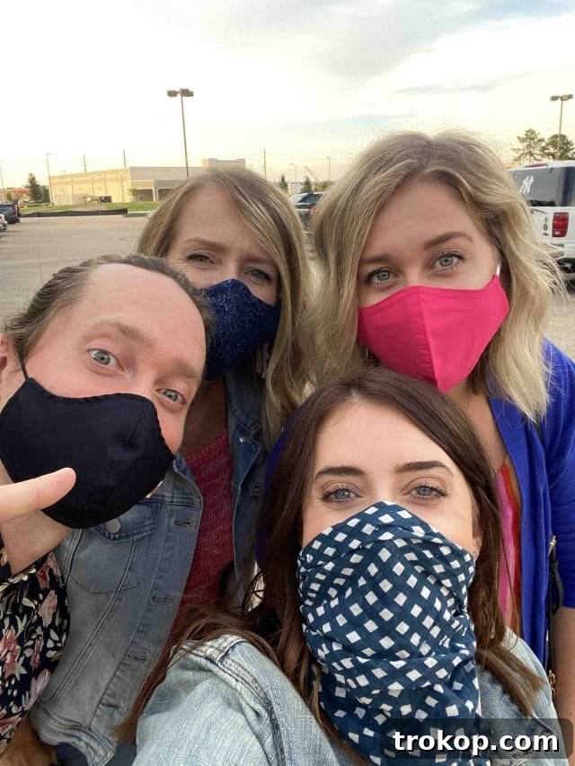 A group of three women and one man wearing face masks, safely enjoying their private movie screening experience at Cinemark.