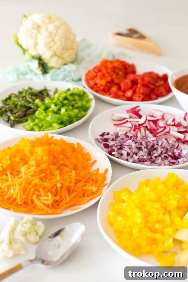 Guilt-Free Cauliflower Pizza Crust for Your Low-Carb Lifestyle 8 Plates showcasing an array of colorful rainbow vegetable toppings for pizza