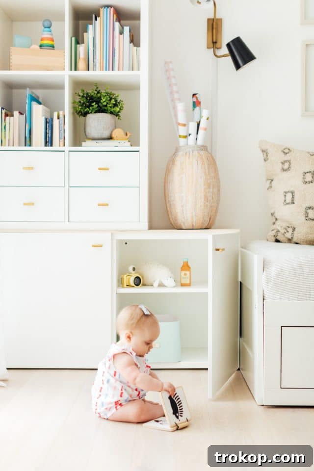 Playroom Makeover: DIY Faux Built-In Cabinets for Organized Fun 3 Child reading a baby book in a bright and organized playroom