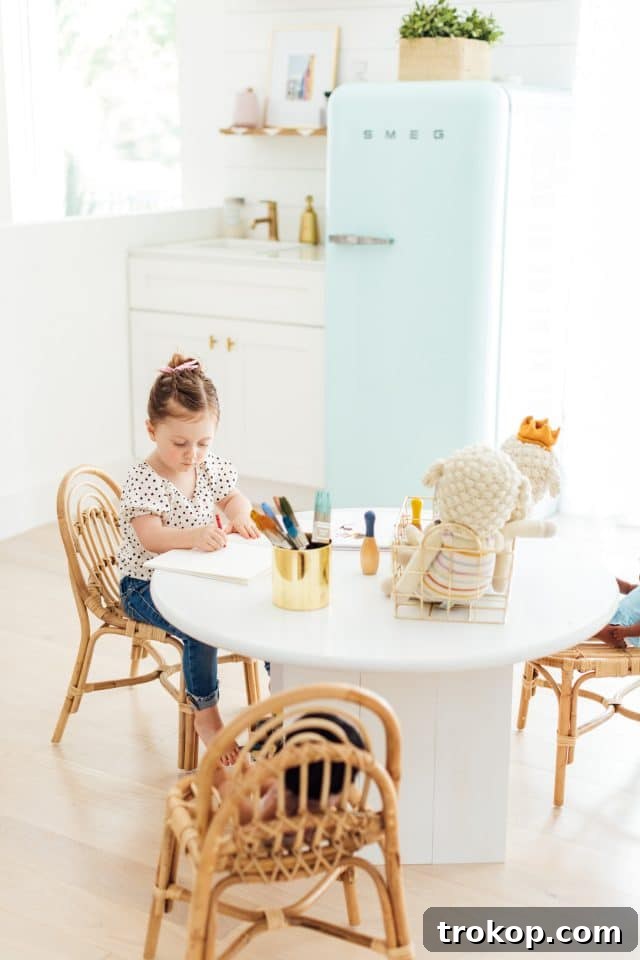 Playroom Makeover: DIY Faux Built-In Cabinets for Organized Fun 9 Little girl at a DIY kids craft table in a modern playroom