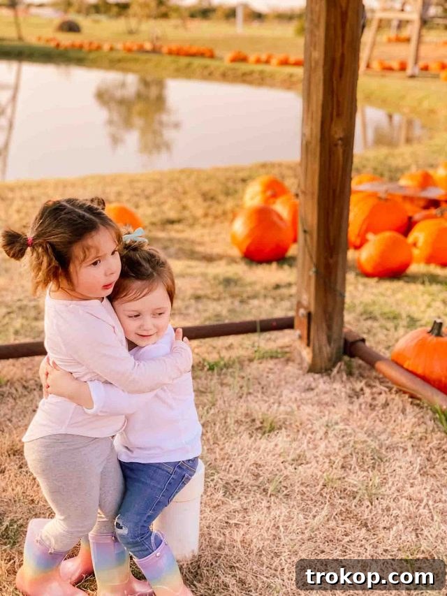 Gwen and Bobbi sharing a warm hug amidst the pumpkins