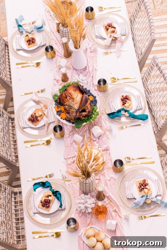 An overhead angled view of a Thanksgiving table setting, featuring a centerpiece turkey, individual cheese plates, and fall decor.