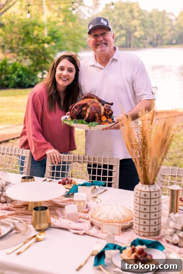 Ashley Rose with her father-in-law, proudly presenting the freshly cooked air fryer turkey after a successful Thanksgiving meal preparation.