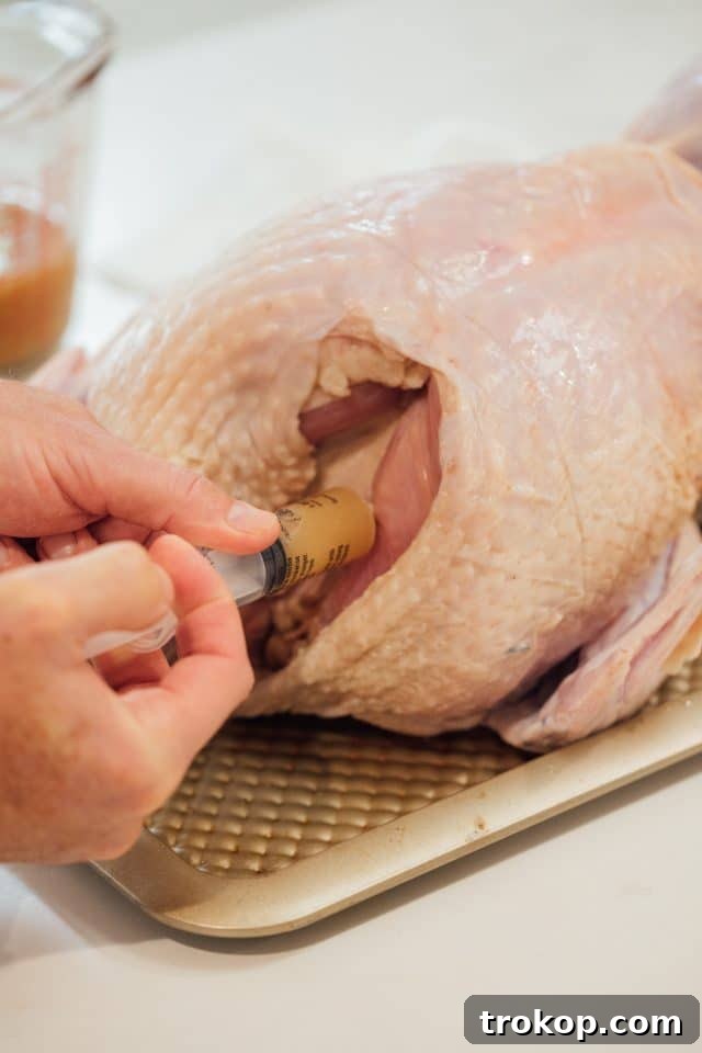 Close-up of the turkey injection process, showing how to infuse the meat with flavor for a juicy result.